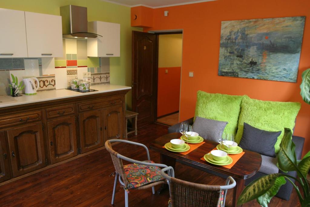 ein Wohnzimmer mit einem Tisch und einer Küche in der Unterkunft Namaste in Saulkrasti