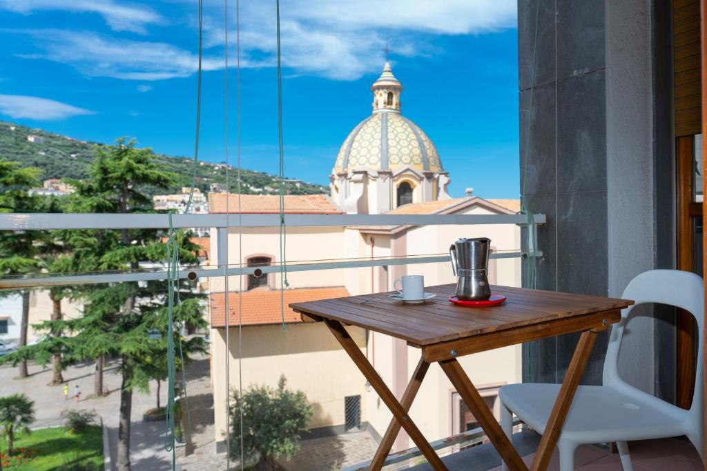 einen Tisch und Stühle auf einem Balkon mit einer Kirche in der Unterkunft Il Campanile in Vico Equense