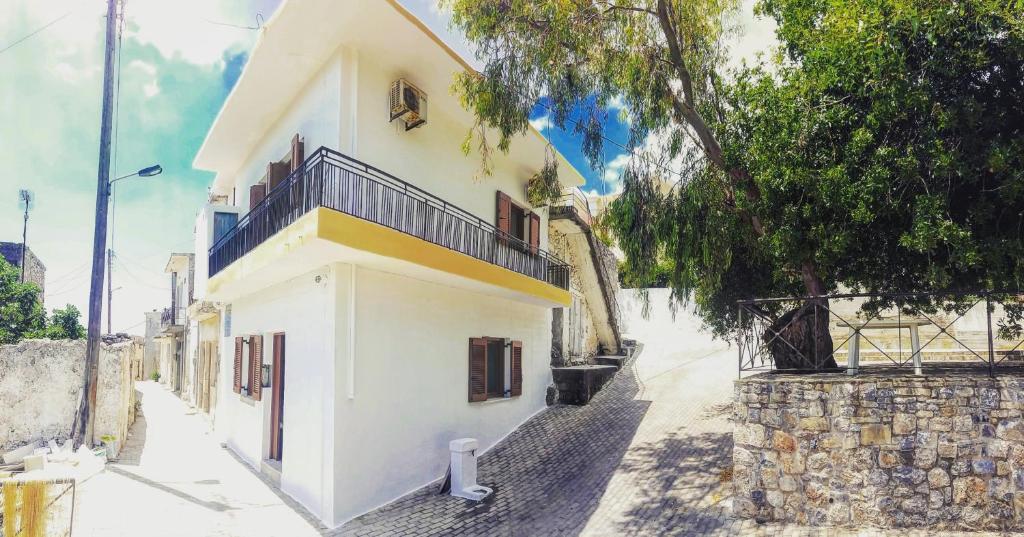 - un bâtiment blanc avec un balcon dans une rue dans l'établissement Pericles Traditional Cretan Home, à Stavrokhórion