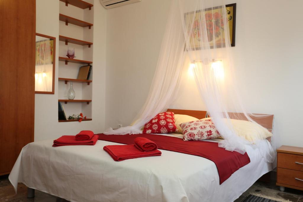 a bedroom with a bed with red towels on it at Foltyn Holiday Home in Selca