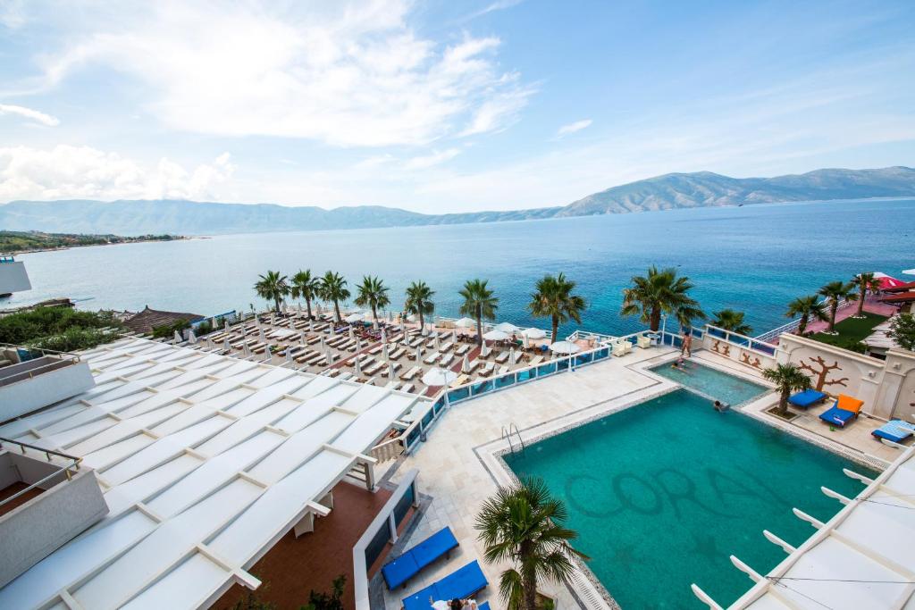 an aerial view of a resort with a pool and chairs at Coral Hotel & Resort in Vlorë