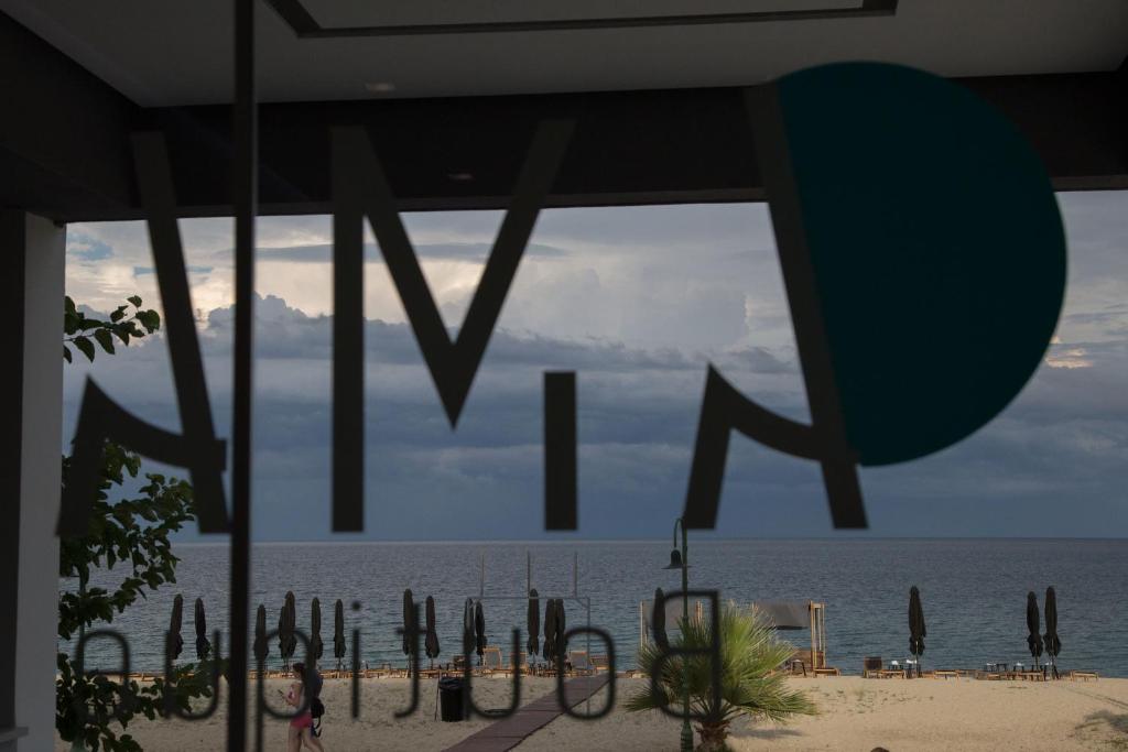 a view of the ocean from a beach with the word miki at Amalia Rooms Sea View in Nea Vrasna