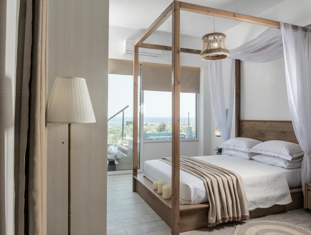 a bedroom with a canopy bed and a large window at Kallia Luxury private in Ierapetra