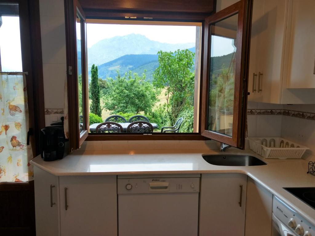 a kitchen with a window with a view of a mountain at Chalet turístico La Jenduda in Ojedo