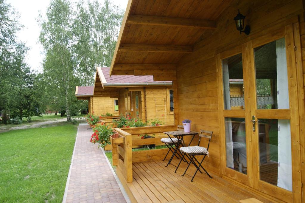 une terrasse couverte d'une maison avec une table et des chaises dans l'établissement Camping Family, à Bronowice