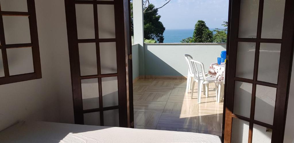 トリンダーデにあるCasa Mar e Montanha 1のテーブルと椅子付きのバルコニーが備わる客室です。