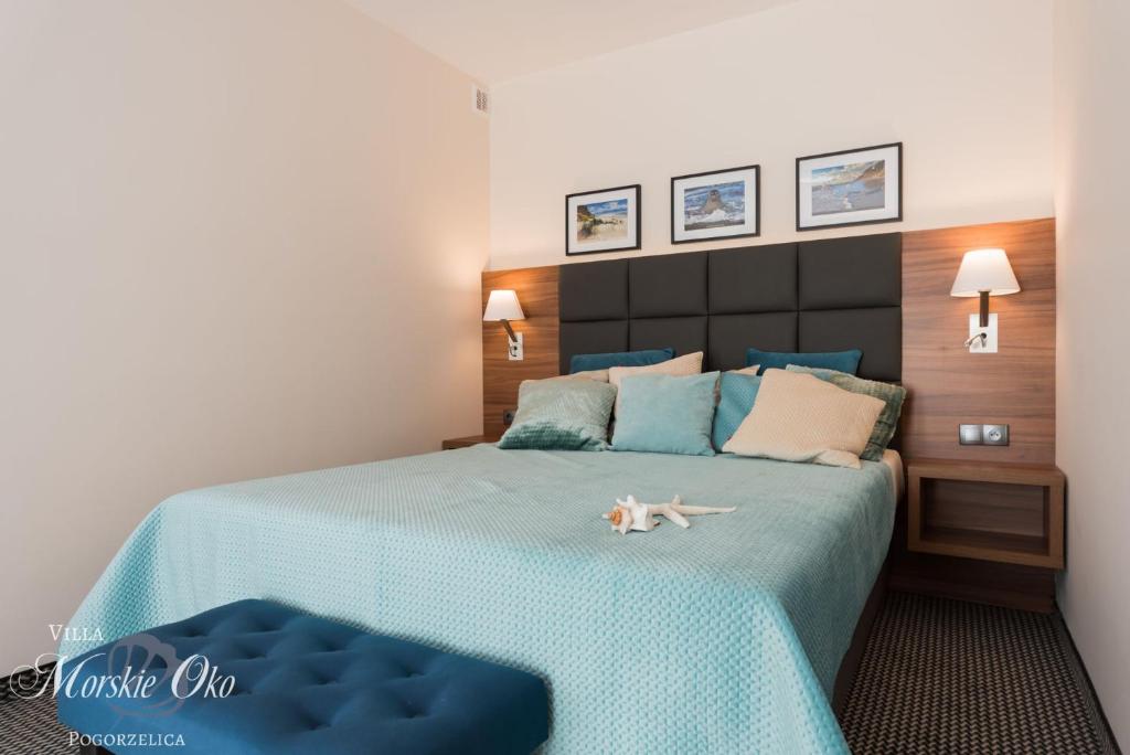 Un dormitorio con una cama azul con un animal de peluche. en villa Morskie Oko en Pogorzelica