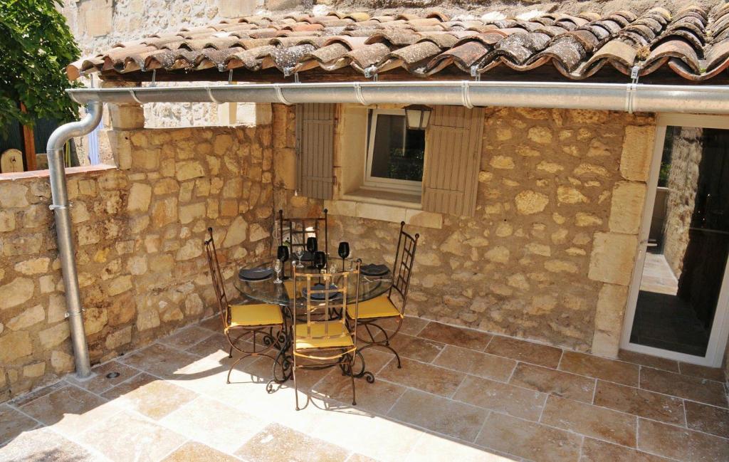 - une terrasse avec une table et des chaises devant un bâtiment en pierre dans l'établissement Au mazet de Carmélina, à Paradou
