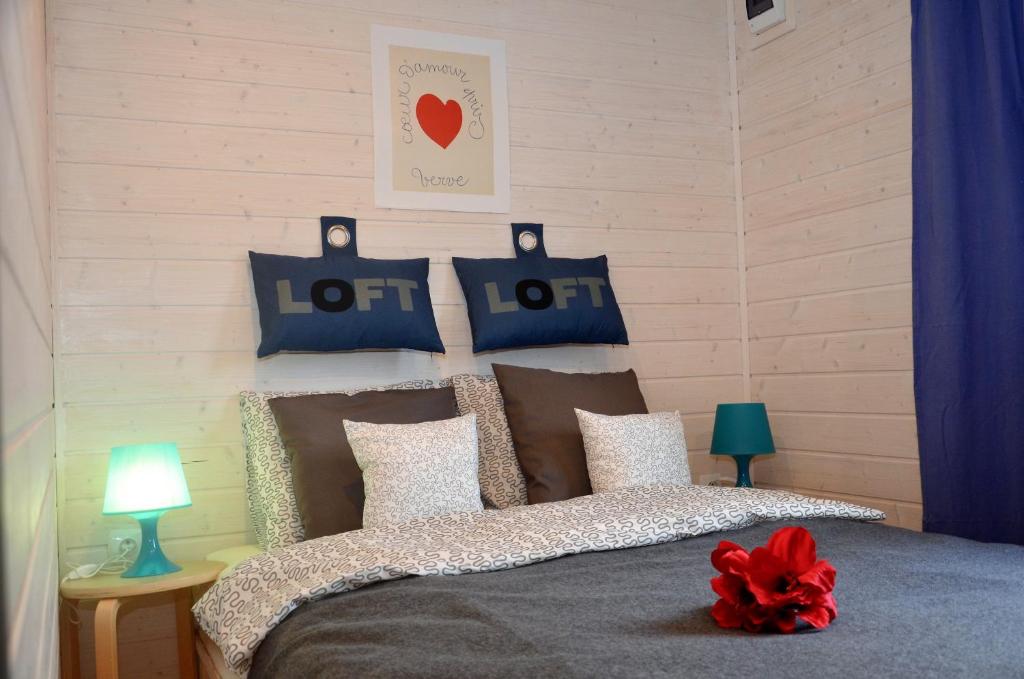 a bedroom with a bed with blue and white pillows at Domki Baltyk in Dąbki