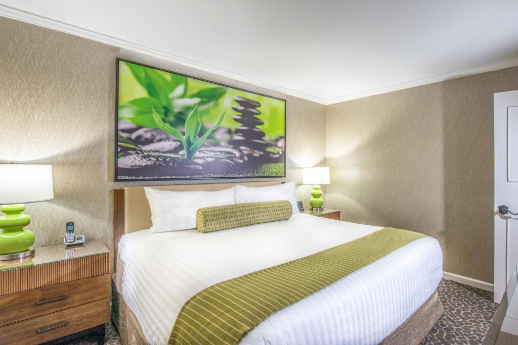 um quarto de hotel com uma cama grande e duas lâmpadas em The Creekside Inn em Palo Alto
