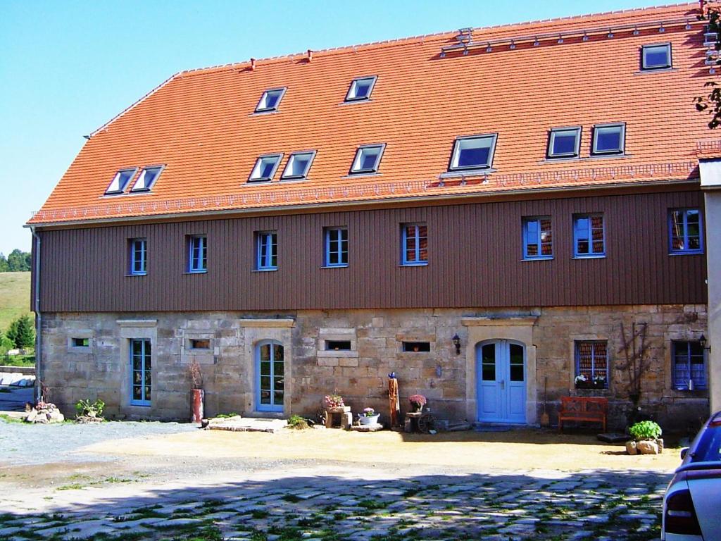 a large brick building with an orange roof at Urlaubsoase-Lindenhof in Pfaffendorf