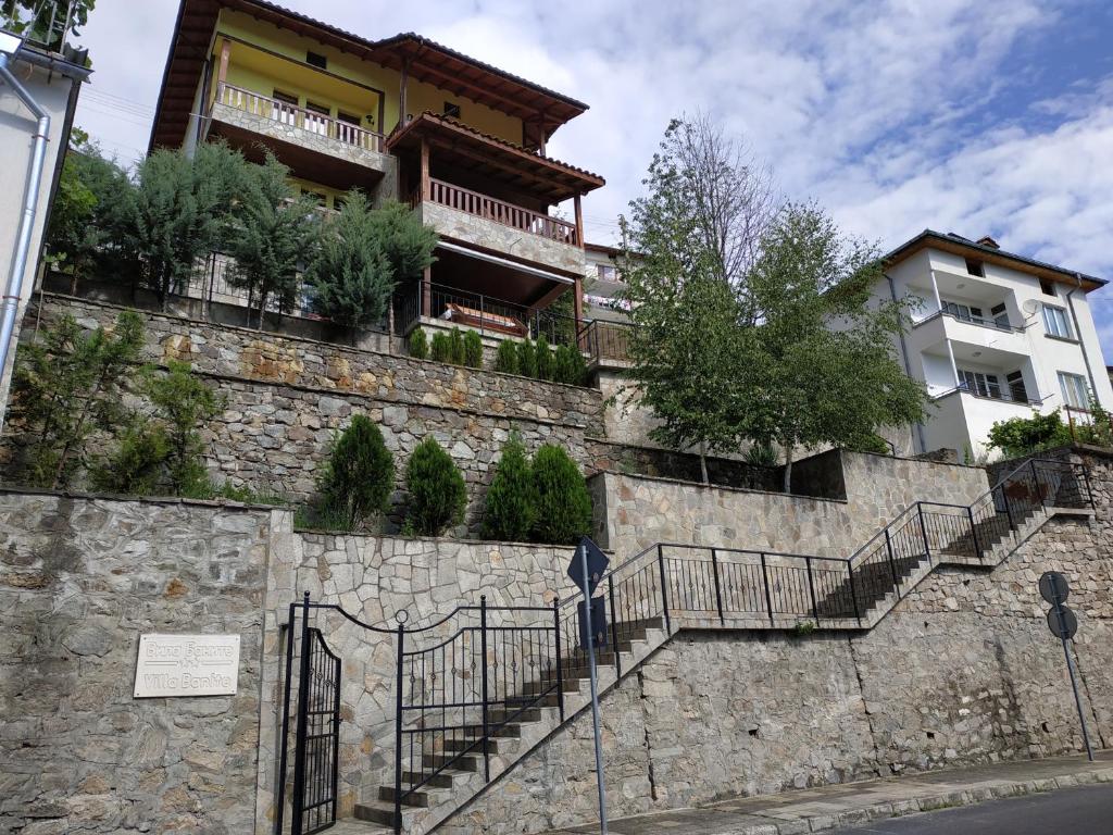 un edificio in cima a un muro di pietra con scale di "Вила Баните" a Banite