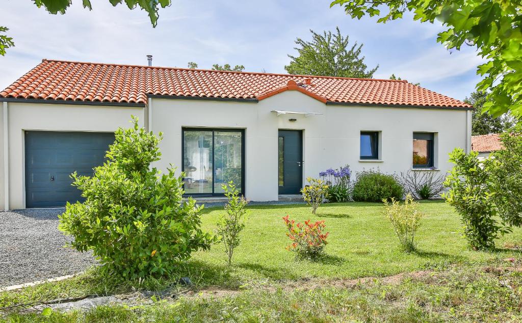 una casa blanca con garaje en Villa d'Eau Douce, en La Mothe-Achard