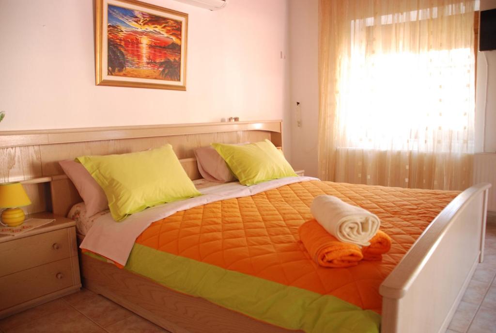 a bedroom with a large bed with yellow and orange sheets at Villa Aleka in Samothráki