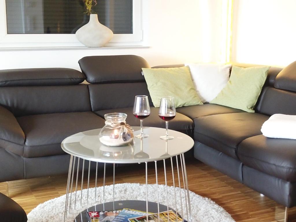 a living room with a couch and two glasses of wine at Ferienwohnung Seenland in Großräschen
