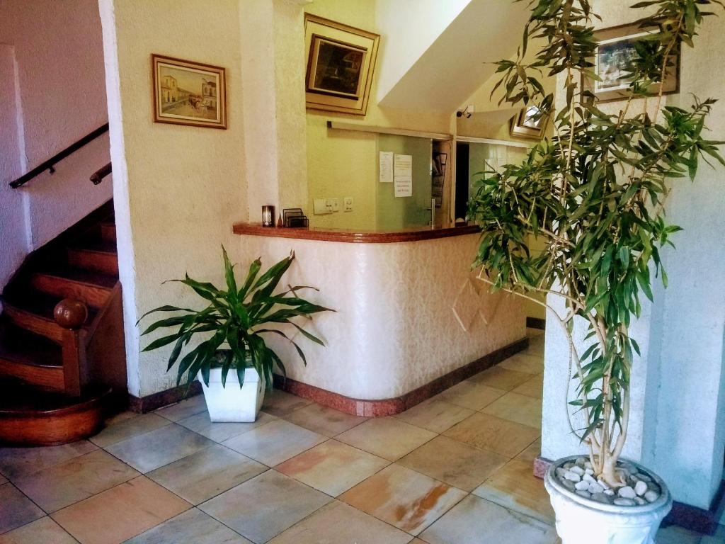 a lobby with two potted plants and a staircase at Grande Hotel Renascença in Juiz de Fora