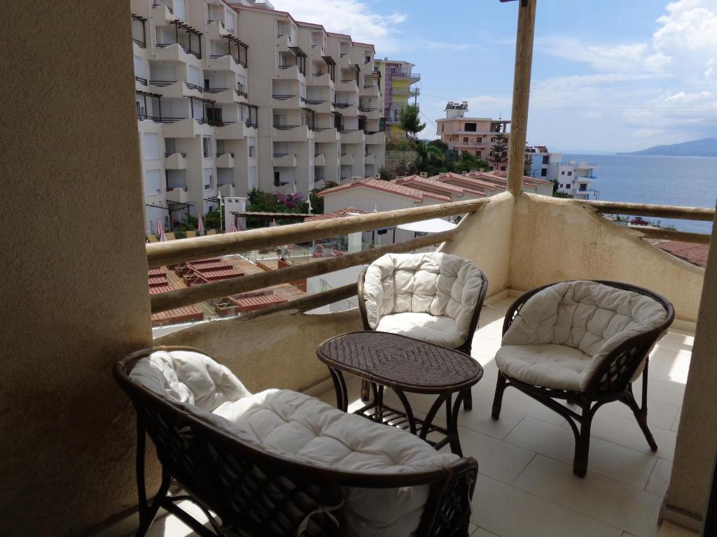 a balcony with chairs and tables and a view of the ocean at Kela Apartment 3 in Sarandë