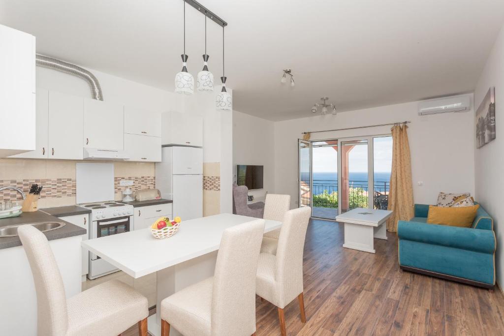 a kitchen and living room with a table and chairs at Apartments Natasa in Sveti Stefan