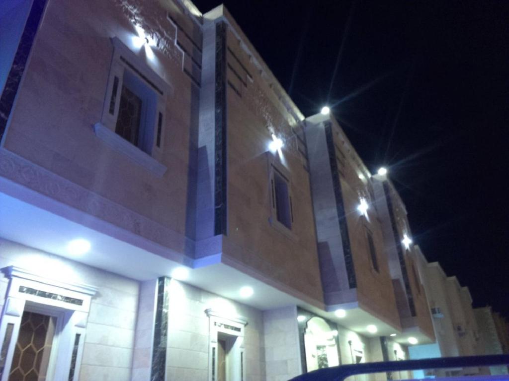 a large building with lights on top of it at night at Al Basam Furnished Units in Yanbu