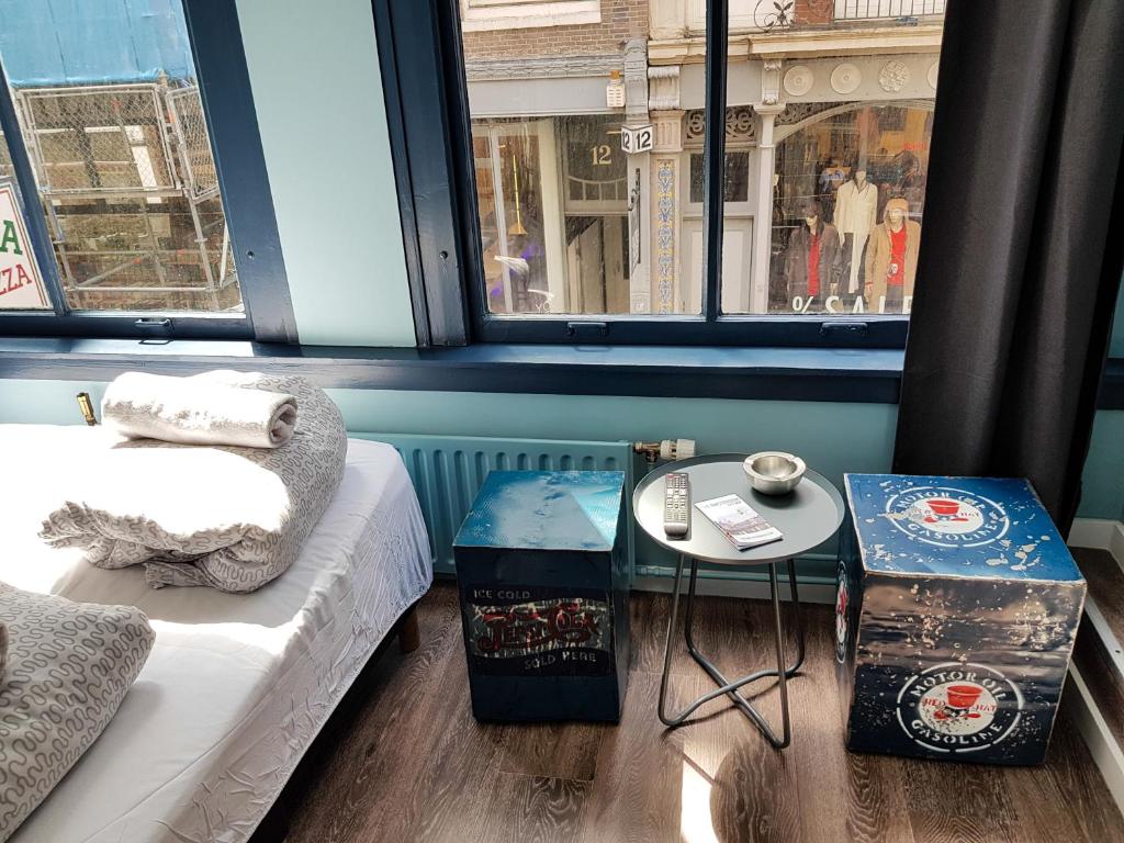 Cette chambre comprend un lit, une table et des fenêtres. dans l'établissement Urban Vibes Guesthouse, à Amsterdam