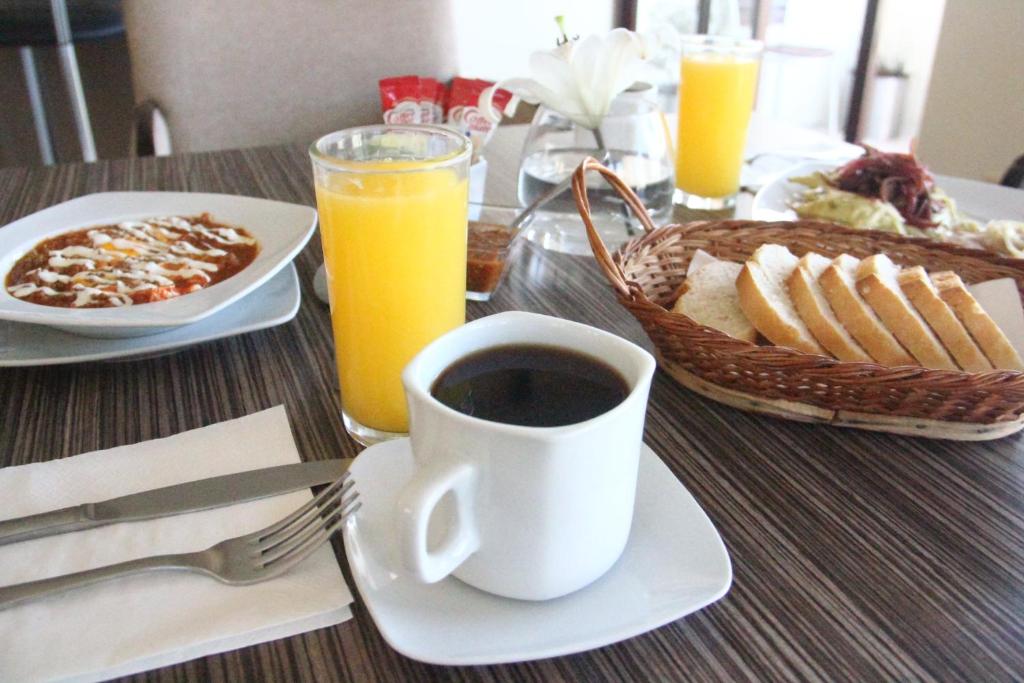 薩卡特卡斯的住宿－卡薩托雷斯酒店，一张桌子,上面放着一杯咖啡和一篮子的食物