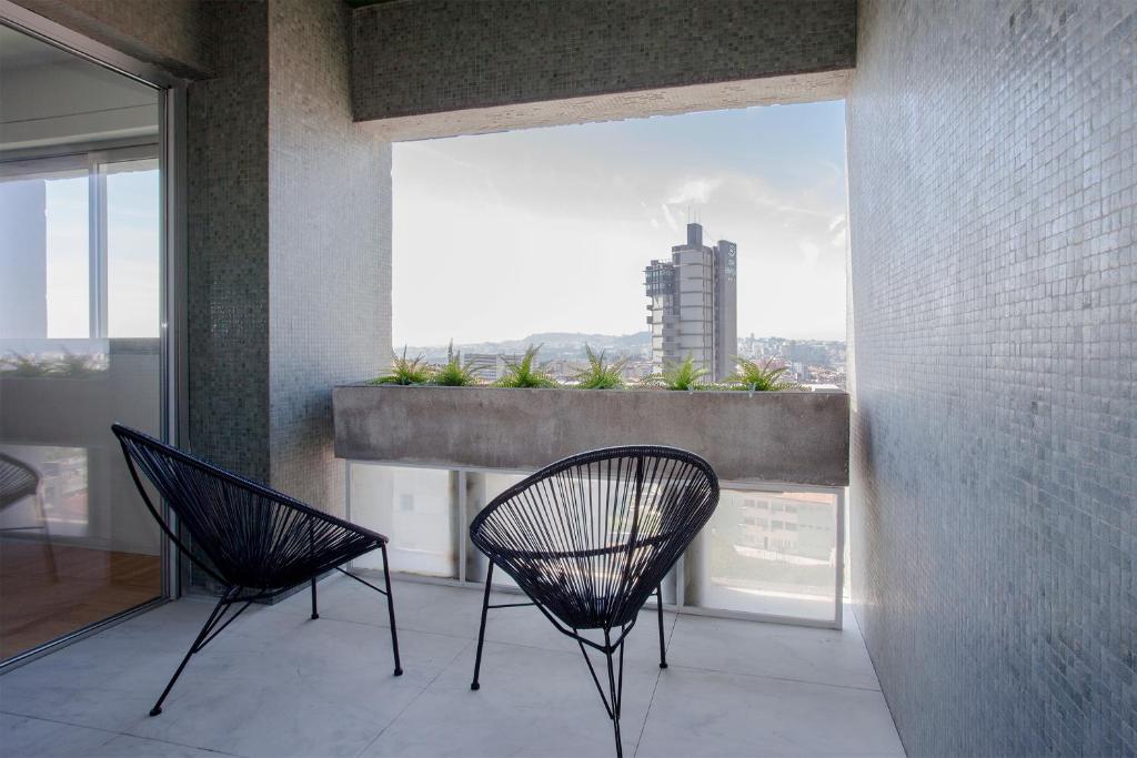 two chairs sitting in a room with a large window at Liiiving in Porto | Downtown Secret Luxury Apartments in Porto