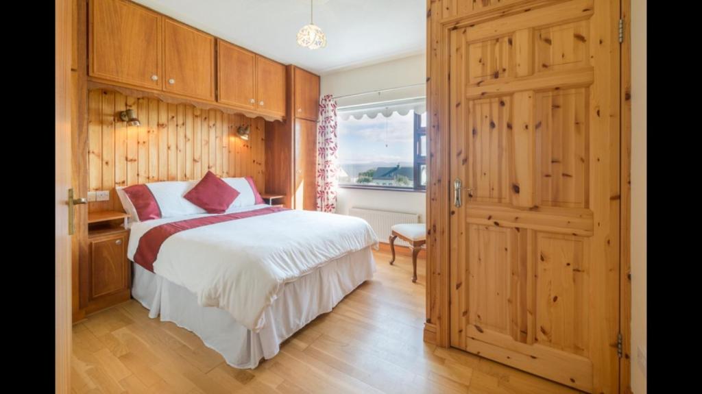 a bedroom with a bed and a wooden door at Beachmount House in Ventry