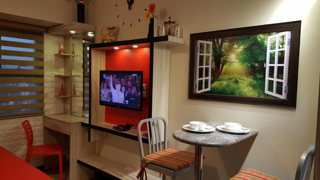 a small table in a room with a tv and a window at Khalil's Horizons 101 Studio Type Condominium in Cebu City