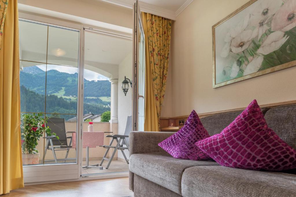 ein Wohnzimmer mit einem Sofa und lila Kissen in der Unterkunft Alpenresidenz-Sonnwend in Zell am Ziller