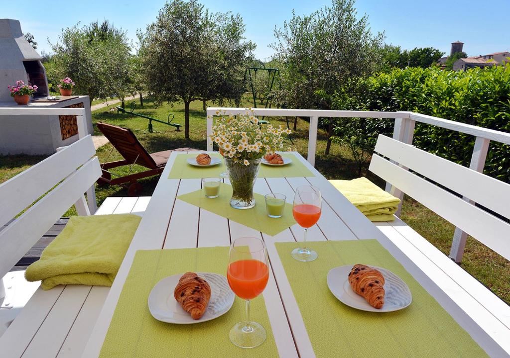 uma mesa com pratos de comida e copos de vinho em Sunset Garden House Vrsar em Vrsar