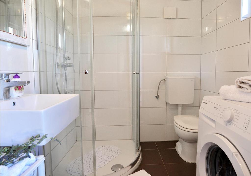 łazienka z umywalką, toaletą i prysznicem w obiekcie Sunset Garden House Vrsar w mieście Vrsar