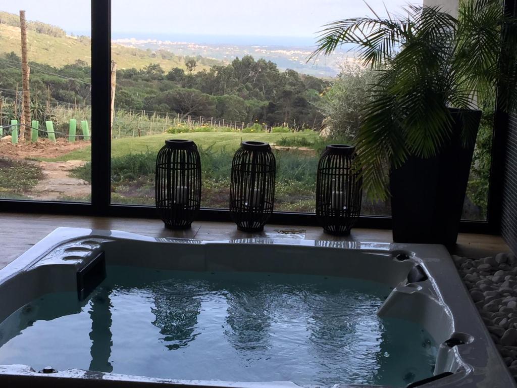 a bath tub with three vases in front of a window at Quinta Vale da Roca in Sintra