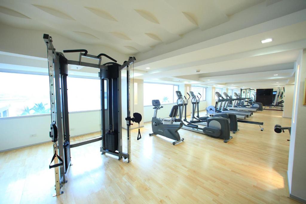 A spacious cardio and cable-training room with bright windows.