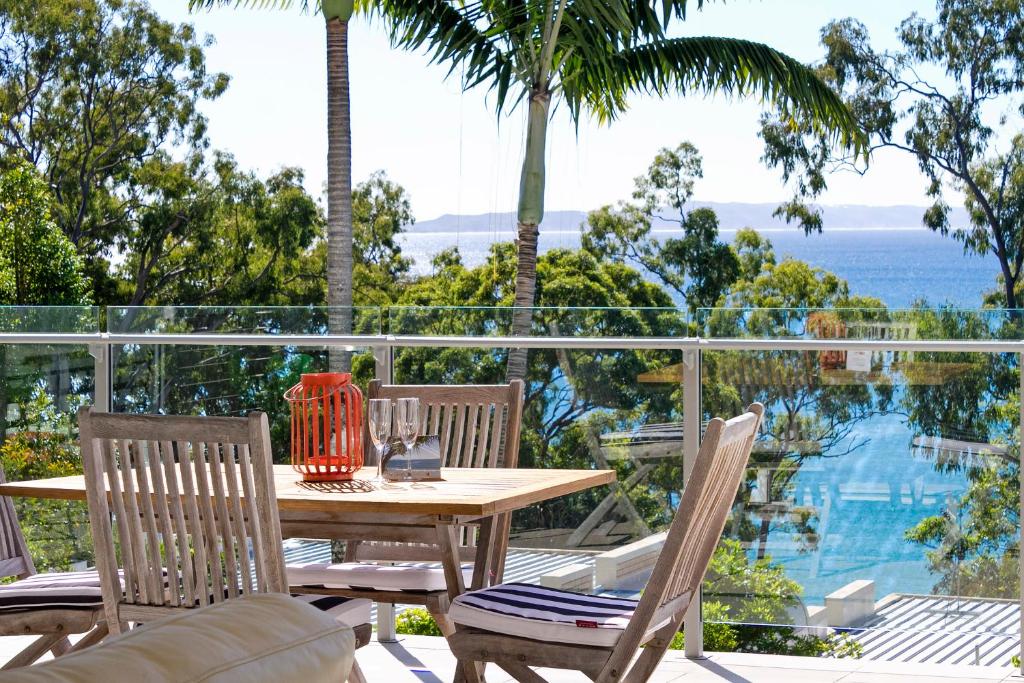 a table and chairs on a patio with a view of the ocean at Allambi Apartment 2, 25 Allambi Rise, Little Cove in Noosa Heads