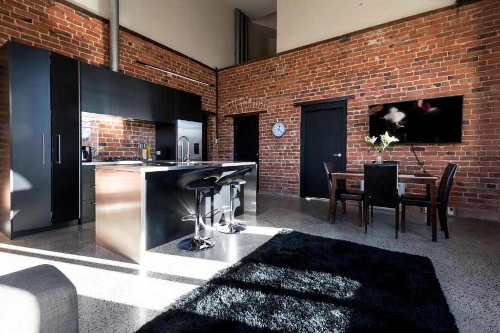 cocina y comedor con pared de ladrillo en The Terminus, en Dunedin