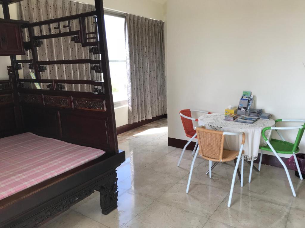 a room with a table and chairs and a table and a bed at Kuo Kuang Hostel in Hualien City