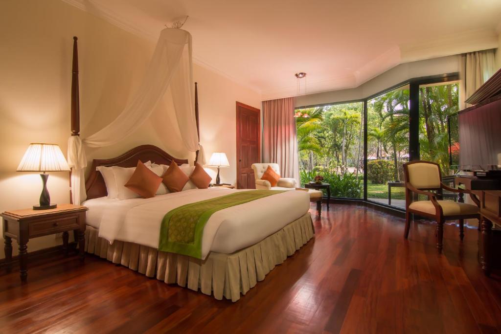Postel nebo postele na pokoji v ubytování Angkor Palace Suite & Villa