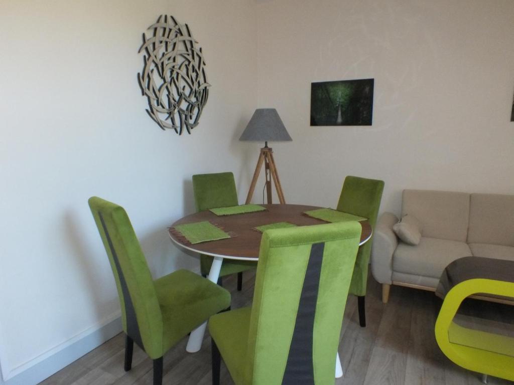 comedor con mesa y sillas verdes en Residence Mifaly, en Châteauroux