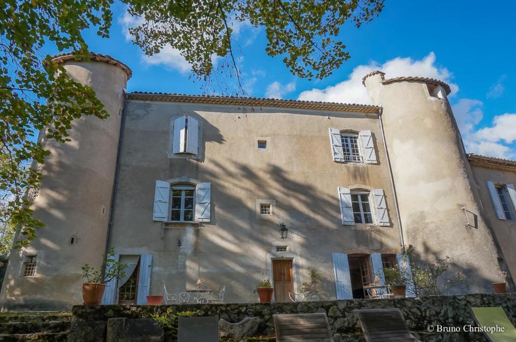 a large stone building with white windows and a blue sky at Chateau de Laric in Chabestan