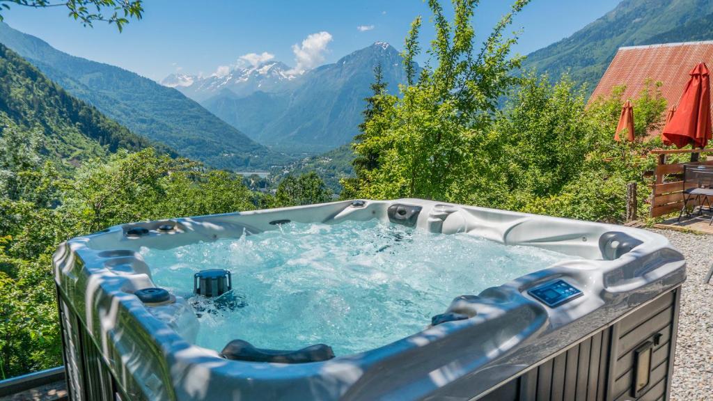 a hot tub with a view of mountains at Chalet La Maitreya in Vaujany