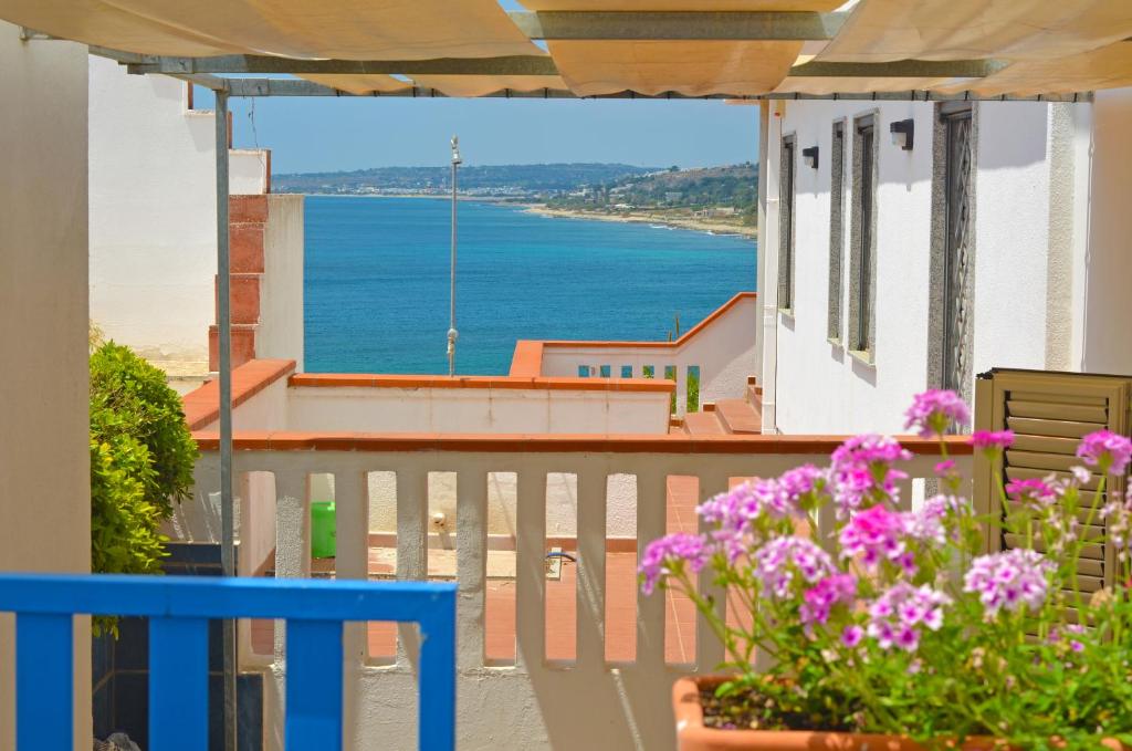 een balkon met bloemen en uitzicht op de oceaan bij Casa Baia Verde in Patù