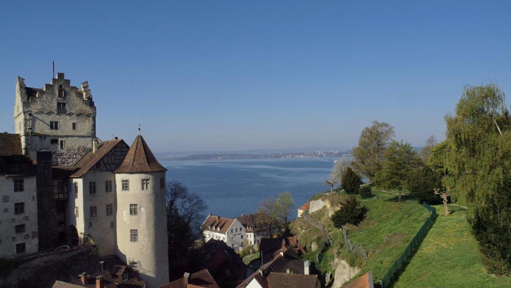 a castle on a hill next to a body of water at Gaestehaus Seliger in Meersburg