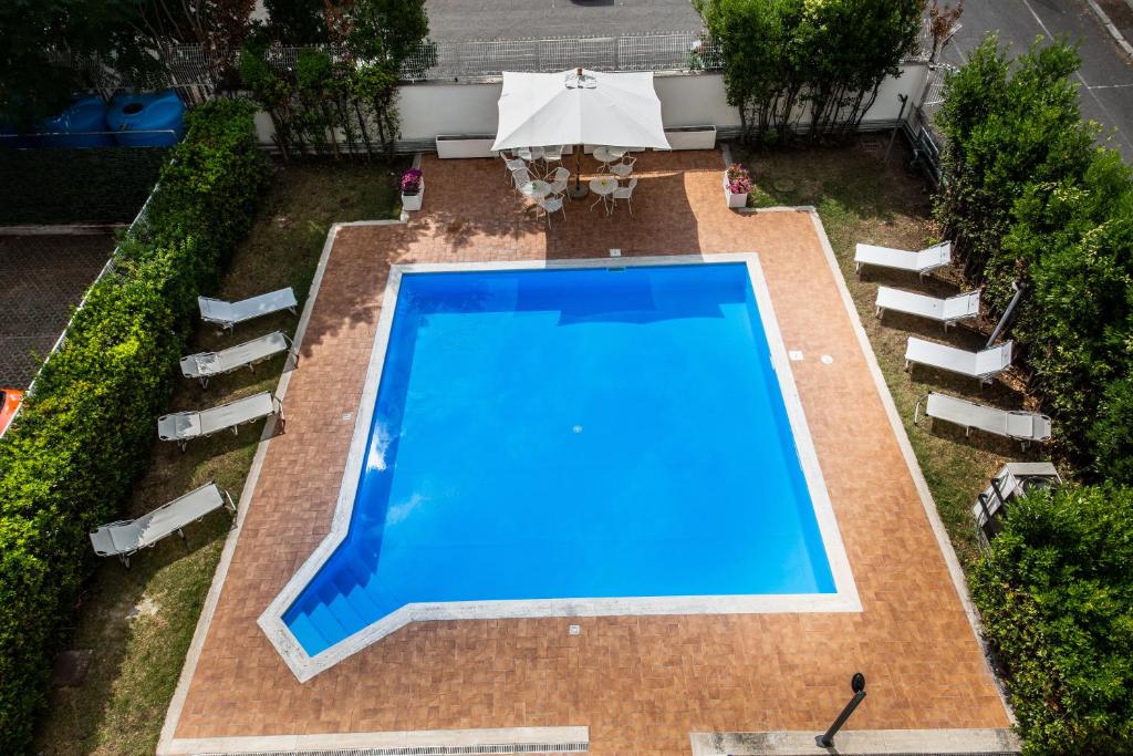 an overhead view of a swimming pool with chairs and an umbrella at Hotel Roma Tor Vergata in Tor Vergata