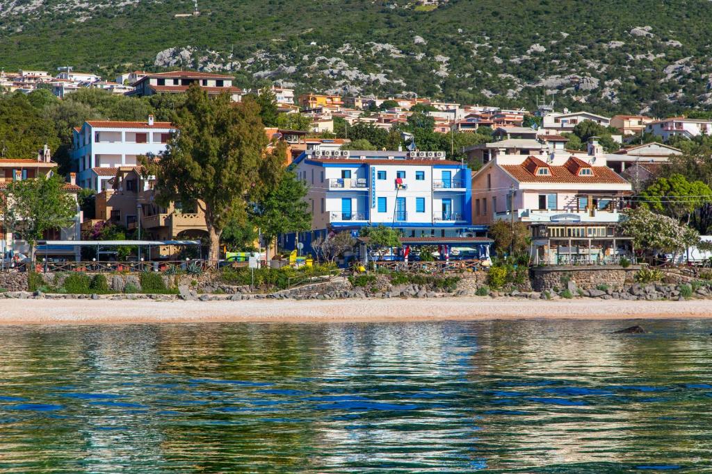a small town with houses and boats on the water at Hotel La Favorita in Cala Gonone