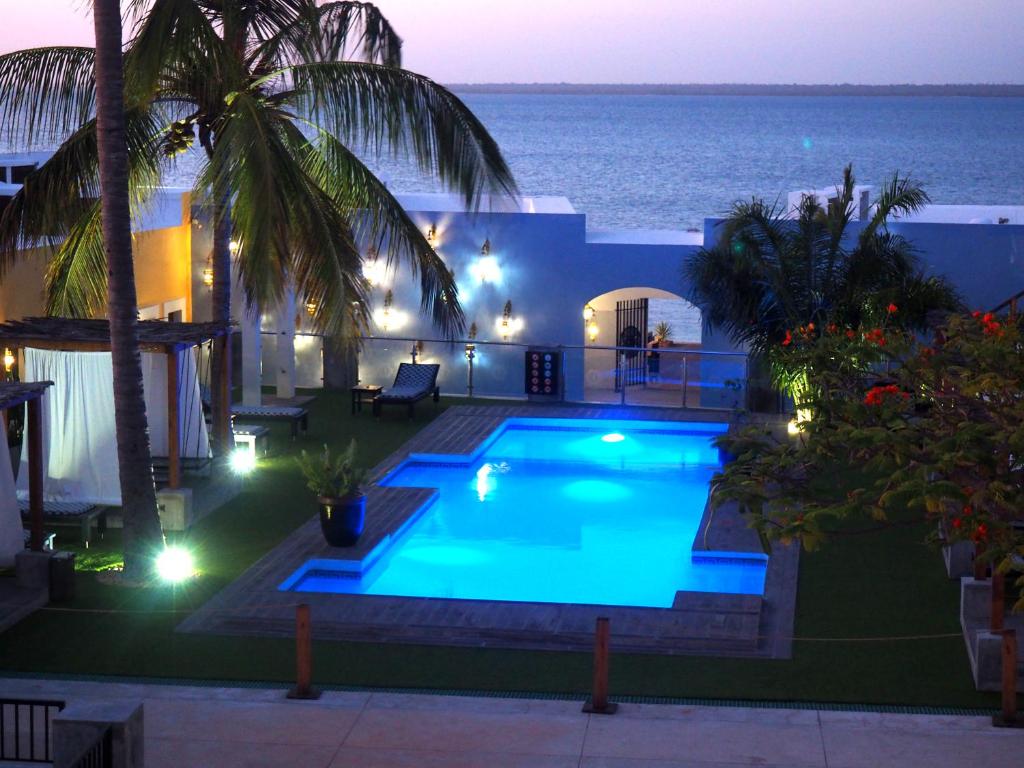 a swimming pool with a view of the ocean at night at Feitoria Boutique Hotel in Ilha de Moçambique