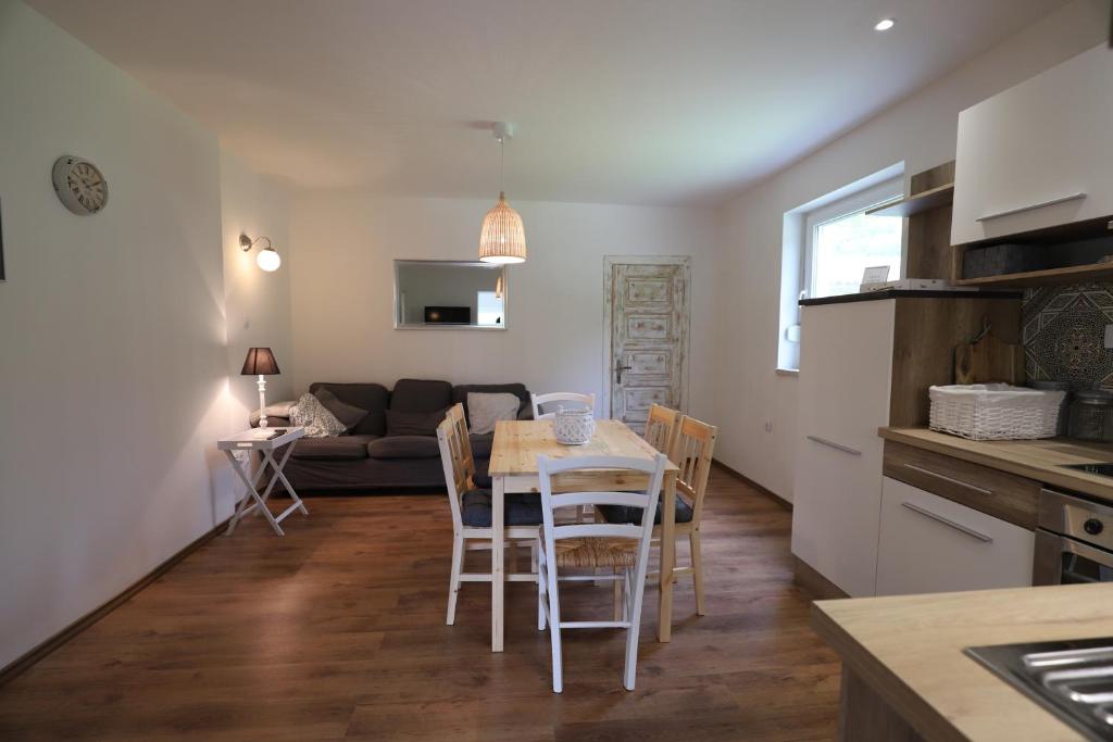 cocina y sala de estar con mesa y sillas en Adventure Cottage with pool and big garden, en Bled