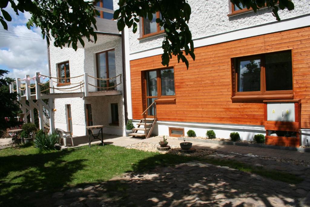 een huis met een houten gevel en een tuin bij Pokoje Noclegi OrzecH in Tczew