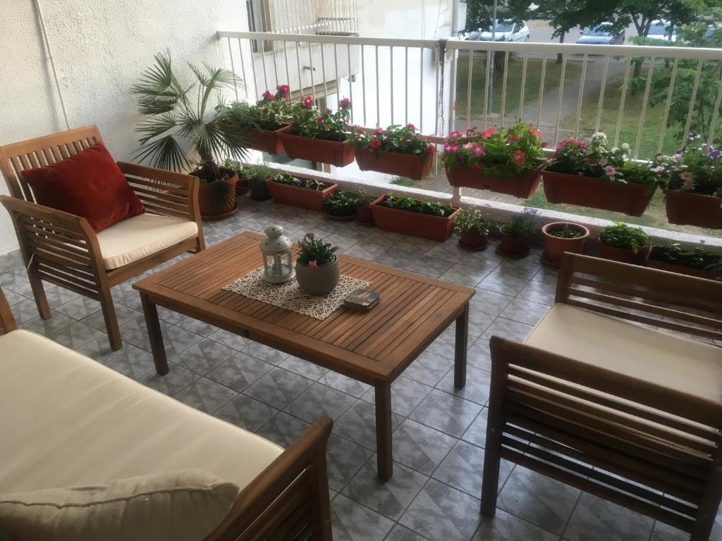 a room with a table and chairs and potted plants at Apartman Zora in Bar