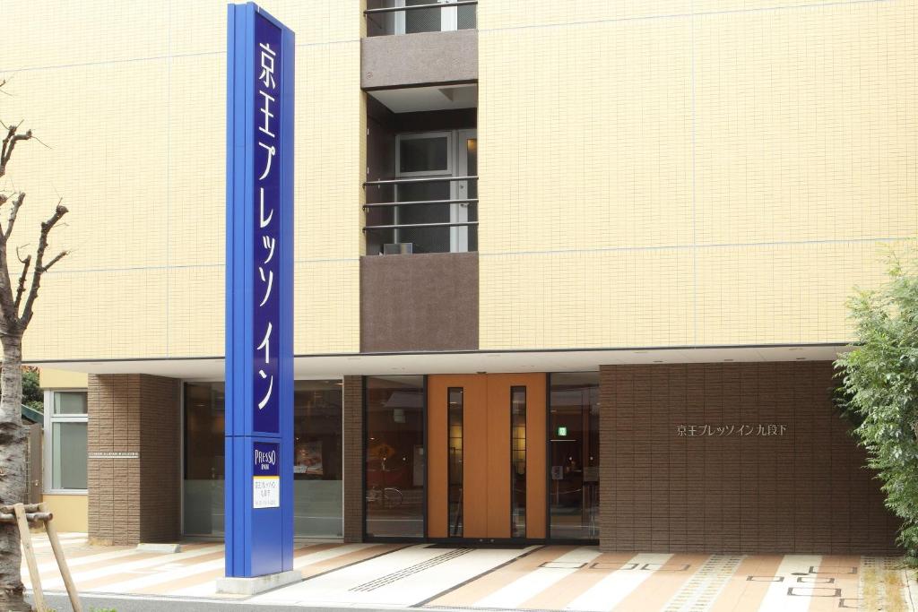 東京にある京王プレッソイン東京九段下の青い看板が目の前にある建物
