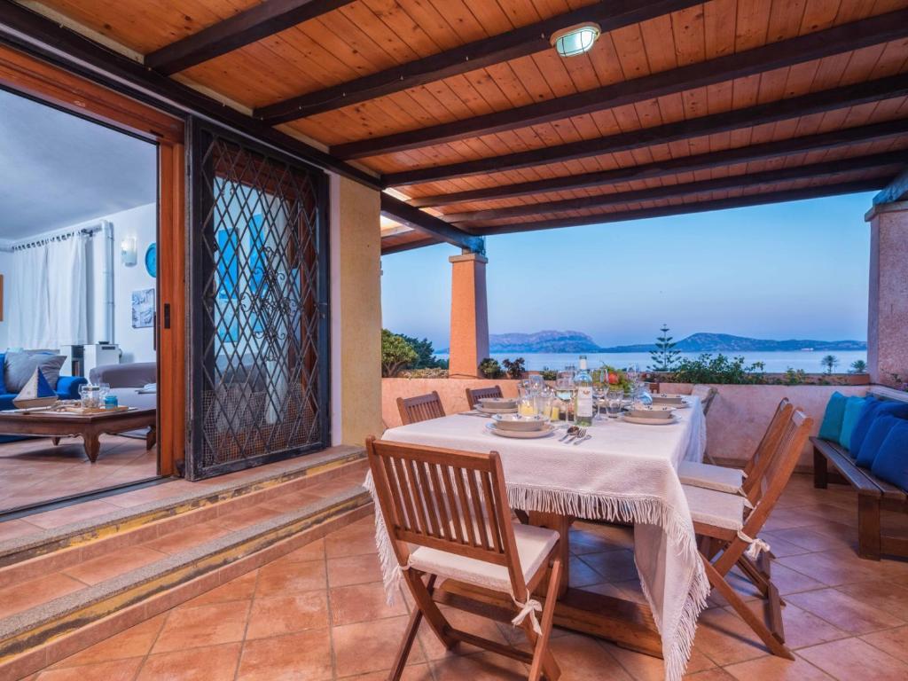 una sala da pranzo con tavolo e sedie su un patio di La Casa sul Mare a Olbia